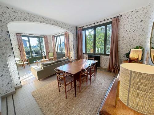 un salon avec une table et un canapé dans l'établissement Maison d'exception à 80m de la plage avec accès direct, proche commerces, terrasse, BBQ, WiFi inclus - FR-1-361-375, à Jullouville