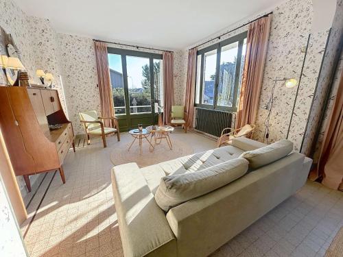 a living room with a couch and a table at Maison d'exception à 80m de la plage avec accès direct, proche commerces, terrasse, BBQ, WiFi inclus - FR-1-361-375 in Jullouville-les-Pins