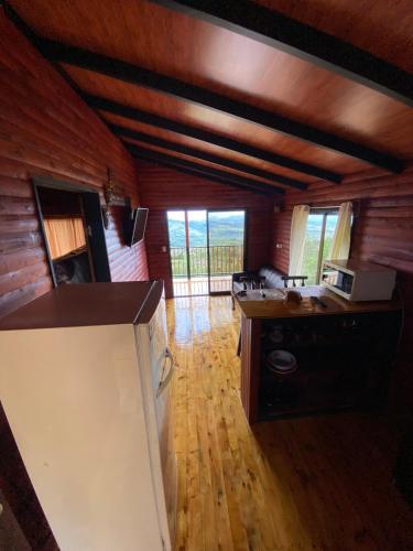 a kitchen with wooden walls and a wooden floor at Cabaña Con Hermosa vista y ambiente de campo in Miravalles