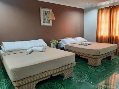 two twin beds in a room with green floors at Panglao Grande Resort 邦劳美丽度假村 in Panglao Island