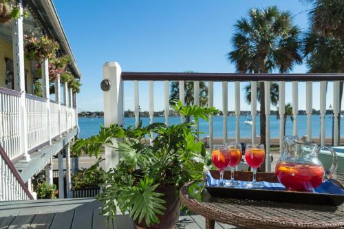 a table with three drinks on a balcony with the ocean at Bayfront Marin House in St. Augustine