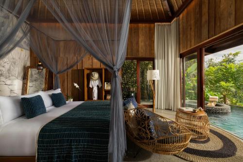 a bedroom with a bed and a swimming pool at Akohara Buahan Village Retreat in Payangan