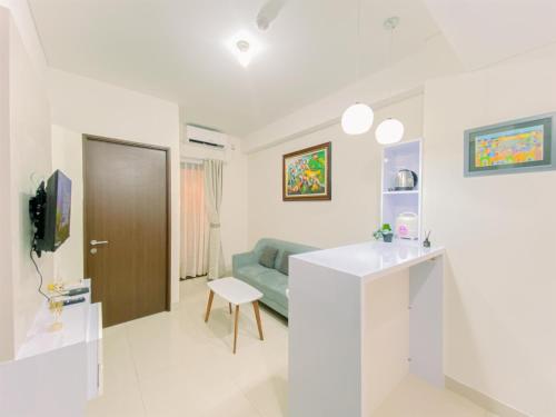 a white living room with a couch and a table at Good Place and Homey 2BR at Transpark Cibubur Apartment near Mall By Travelio in Depok
