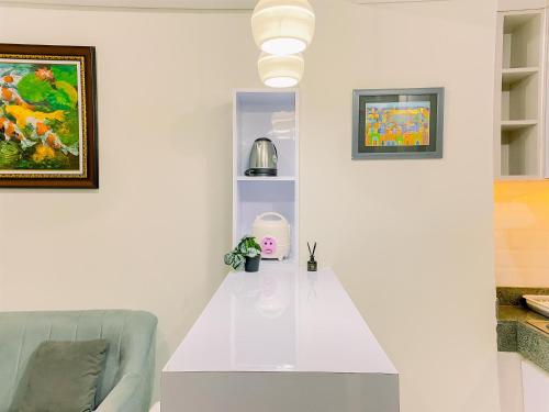 a living room with a white table and a couch at Good Place and Homey 2BR at Transpark Cibubur Apartment near Mall By Travelio in Depok