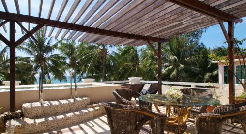 a patio with a table and chairs and palm trees at Boracay Mandarin Island Hotel in Boracay