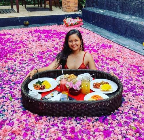 a woman sitting in a tray of food on a carpet of flowers at Classic Villa with Private Pool in Kuta