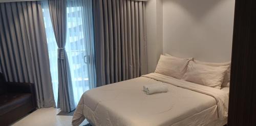 ein weißes Bett in einem Zimmer mit Fenster in der Unterkunft Tambuli Seaside Residences Buyong Road Maribago Lapu Lapu City in Cogon