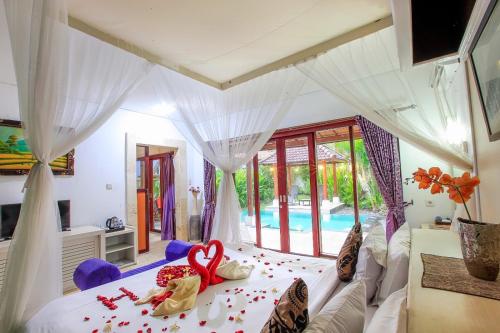 a bedroom with a bed with a heart on it at Classic Villa with Private Pool in Kuta
