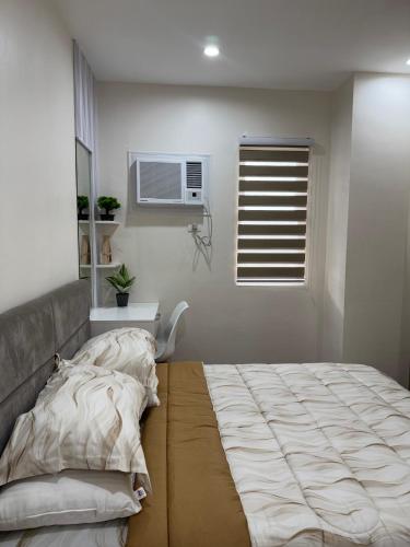 a bedroom with a large bed and a window at Alder - One Bedroom Condo Unit with Balcony in Davao City