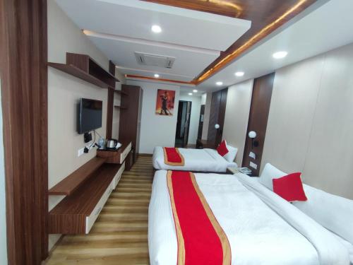 a hotel room with two beds and a tv at Hotel Ambrosia, Charikot, dolakha in Charikot