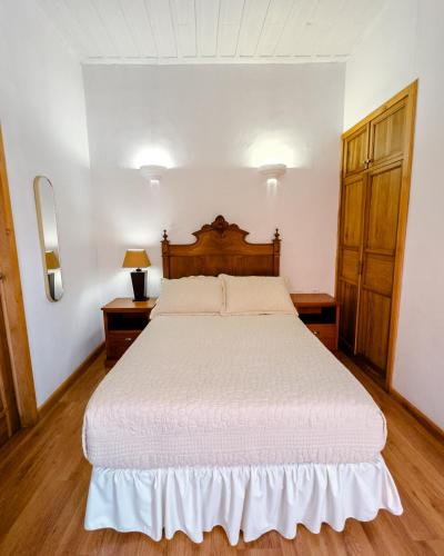 a bedroom with a large bed with a wooden headboard at Hotel Boutique Casa Montalvo Cuenca in Cuenca