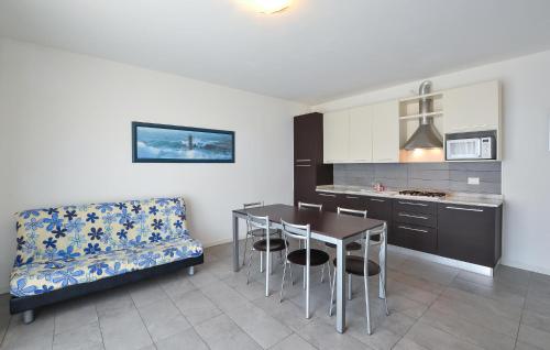 eine Küche mit einem Tisch und einer Couch in einem Zimmer in der Unterkunft Amazing Apartment In Cavallino-Treporti in Cavallino-Treporti