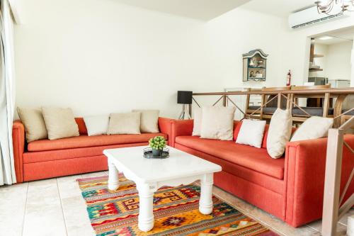 a living room with two red couches and a table at Condos Privados en Huatulco in Tangolunda