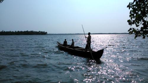 a group of people in a boat on the water at West Wind Homez - Home Stay in Cochin