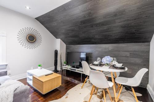 a living room with a wooden wall with a table and chairs at Modern City Suite with Rooftop Patios in Toronto