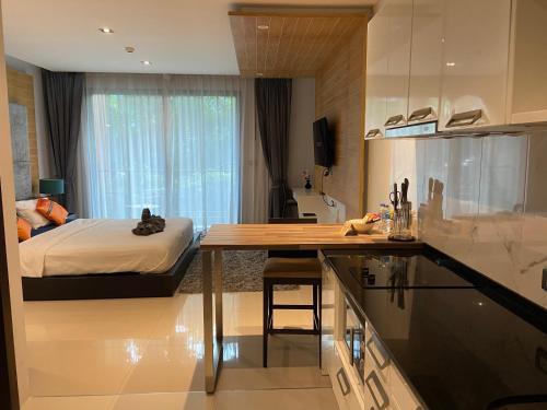 a kitchen and a bedroom with a bed and a table at Emerald Terrace Condo 5-Studio Garden zen in Patong Beach