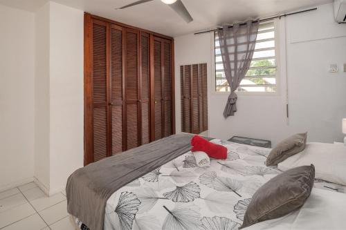 a bedroom with a large bed and a window at EBT House, appartement, jacuzzi vue mer, 10 min aéroport et port in Baimbridge