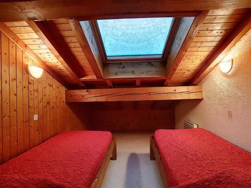 une chambre mansardée avec deux lits et une fenêtre dans l'établissement Appartement 8 pers, La Clusaz, parking, animaux bienvenus - FR-1-818-5, à La Clusaz