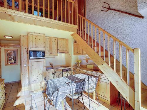 une cuisine avec une table et un escalier dans une maison dans l'établissement Duplex pour 6 à La Clusaz, animaux admis, parking - FR-1-818-28, à La Clusaz