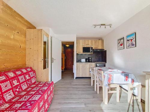 un salon avec un canapé rouge et une cuisine dans l'établissement Studio cosy à La Clusaz pour 4 pers, WIFI, garage, animaux admis - FR-1-818-3, à La Clusaz