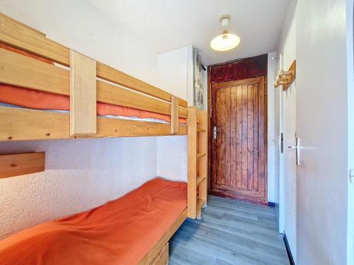 Cette chambre comprend 2 lits superposés et une porte. dans l'établissement Studio cosy à La Clusaz pour 4 pers, WIFI, garage, animaux admis - FR-1-818-3, à La Clusaz