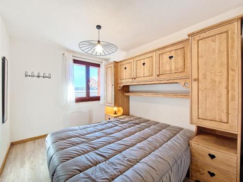 une chambre avec un lit avec une armoire en bois dans l'établissement Appartement cosy à La Clusaz, 6 pers, WiFi, parking, animaux admis - FR-1-818-19, à La Clusaz
