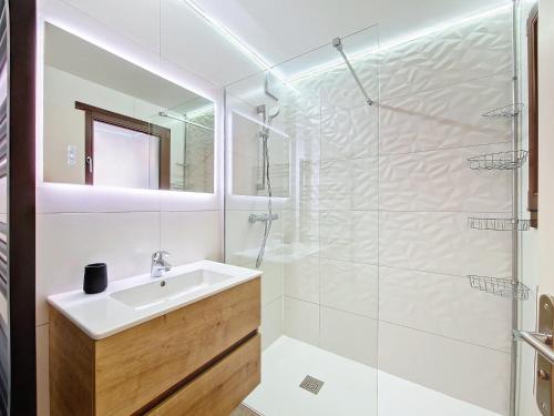 une salle de bain blanche avec un lavabo et une douche dans l'établissement Appartement cosy à La Clusaz, 6 pers, WiFi, parking, animaux admis - FR-1-818-19, à La Clusaz