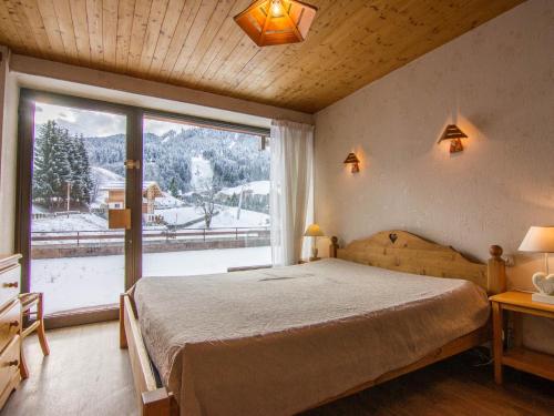 une chambre avec un lit et une grande fenêtre dans l'établissement La Clusaz : Apt 10 pers, terrasse, wifi, animaux ok - FR-1-818-48, à La Clusaz