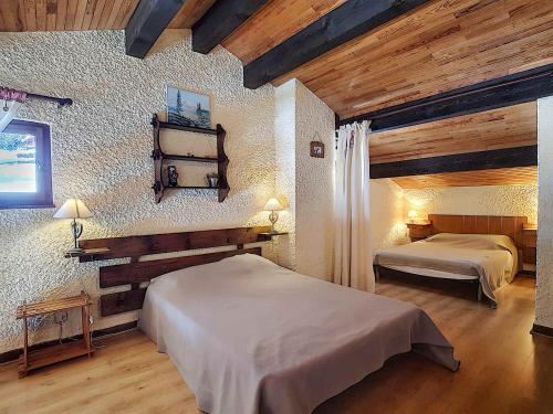 deux lits dans une chambre avec plafonds en bois dans l'établissement Duplex 6 pers avec Cheminée, Animaux admis - FR-1-818-50, à La Clusaz