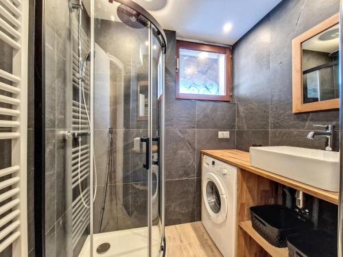 une salle de bain avec douche et lavabo et une machine à laver dans l'établissement Duplex 6 pers avec Cheminée, Animaux admis - FR-1-818-50, à La Clusaz