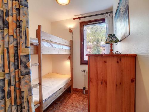 une chambre avec deux lits superposés et une fenêtre dans l'établissement Appartement cosy à La Clusaz - 6 pers, animaux admis, parking - FR-1-818-76, à La Clusaz