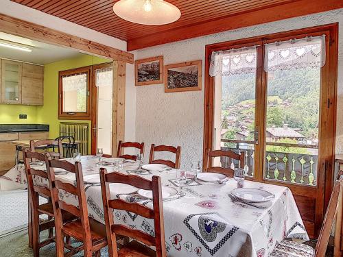 une salle à manger avec une table et des chaises et une fenêtre dans l'établissement La Clusaz : Appartement 7 pers avec balcons, animaux admis, parking - FR-1-818-2, à La Clusaz