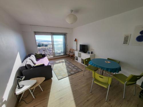 un salon avec un canapé et une table dans l'établissement Studio neuf proche plage et commerces, balcon vue mer - FR-1-92-945, à Les Sables-dʼOlonne