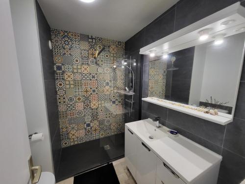 une salle de bain avec un lavabo blanc et un miroir dans l'établissement Studio neuf proche plage et commerces, balcon vue mer - FR-1-92-945, à Les Sables-dʼOlonne