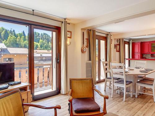 un salon avec une table et des chaises et un balcon dans l'établissement Appartement 3 pièces à La Clusaz pour 6 pers, animaux acceptés, parking - FR-1-818-12, à La Clusaz