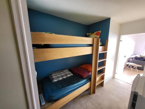 Ce lit superposé se trouve dans un dortoir doté d'un mur bleu. dans l'établissement Studio neuf proche plage et commerces, balcon vue mer - FR-1-92-945, à Les Sables-dʼOlonne