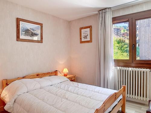 une chambre avec un grand lit et une fenêtre dans l'établissement Appartement 3 pièces à La Clusaz pour 6 pers, animaux acceptés, parking - FR-1-818-12, à La Clusaz