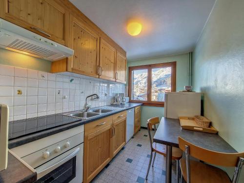La cuisine est équipée d'un évier, d'un réfrigérateur et d'une table. dans l'établissement La Clusaz : Appartement 6 pers, animaux, parking - FR-1-818-22, à La Clusaz