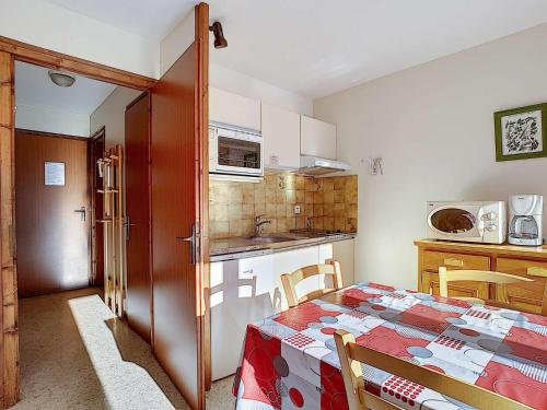 une cuisine avec une table et une cuisine avec une table et des chaises dans l'établissement Studio cosy à La Clusaz - 5 pers, parking, Wi-Fi et animaux acceptés - FR-1-818-47, à La Clusaz