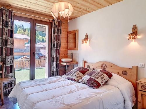une chambre avec un lit et une grande fenêtre dans l'établissement La Clusaz : Appt 6 pers, Terrasse Sud, Animaux OK, Parking - FR-1-818-49, à La Clusaz