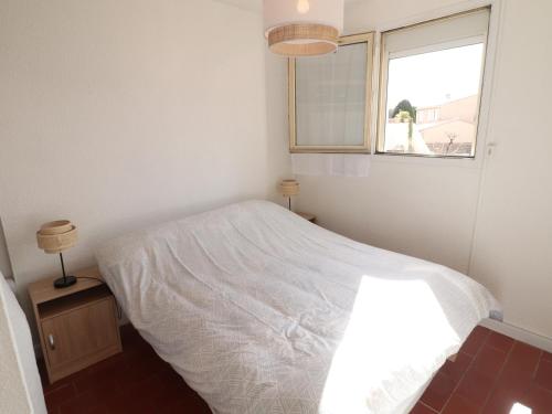 une chambre avec un lit blanc et une fenêtre dans l'établissement Charmant 2 pièces avec parking, proche plage - FR-1-472-206, à Sète