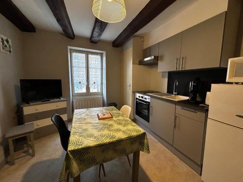 une cuisine avec une table et une cuisine avec une table et des chaises dans l'établissement Studio centre La Roche-Posay, Wifi, parking gratuit - FR-1-541-161, à La Roche-Posay