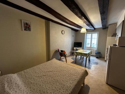 Cette chambre comprend un lit, une table et une cuisine. dans l'établissement Studio centre La Roche-Posay, Wifi, parking gratuit - FR-1-541-161, à La Roche-Posay