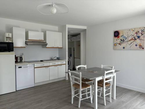 une cuisine avec une table et des chaises dans une pièce dans l'établissement Saint-Palais : T2 3 étoiles, proche plage, terrasse sud, parking, clim et Wifi - FR-1-738-36, à Saint-Palais-sur-Mer