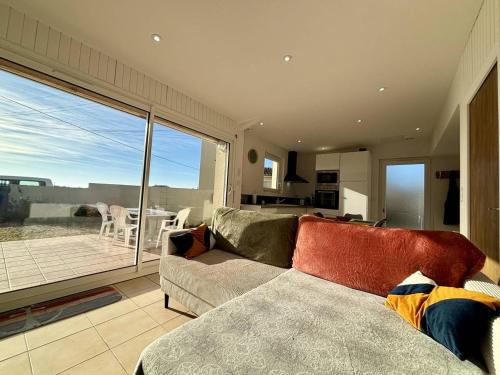 un salon avec un canapé et une grande fenêtre dans l'établissement Maison calme 2 chambres près mer, parking, terrasse - FR-1-246A-334, à Saint-Denis-dʼOléron