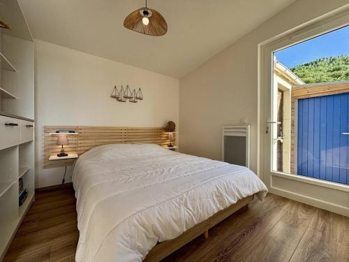 une chambre avec un grand lit et une grande fenêtre dans l'établissement Maison calme 2 chambres près mer, parking, terrasse - FR-1-246A-334, à Saint-Denis-dʼOléron