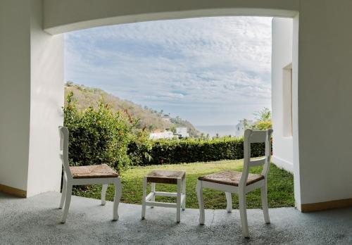 two chairs sitting on a porch with a view at Condos Privados en Huatulco in Tangolunda