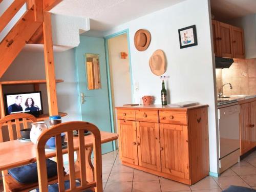 une cuisine avec une table en bois et une salle à manger dans l'établissement Gruissan : Studio Mezzanine Confort, Parking Privé, Proche Commerces et Plages - FR-1-229-891, à Gruissan