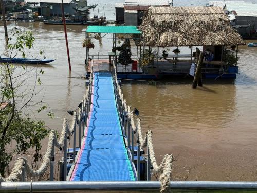 a walkway in the water next to a river at ISLAND HOMESTAY TIỀN GIANG in Ấp Tân An Thi