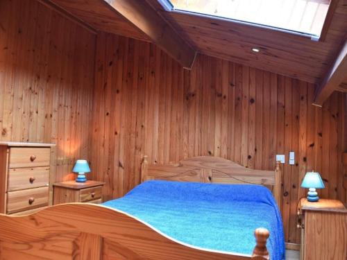 - une chambre avec des murs en bois et un lit avec des draps bleus dans l'établissement Gruissan : Studio Mezzanine Confort, Parking Privé, Proche Commerces et Plages - FR-1-229-891, à Gruissan